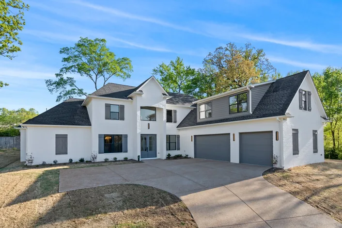 A third completed home, white with a dark roof