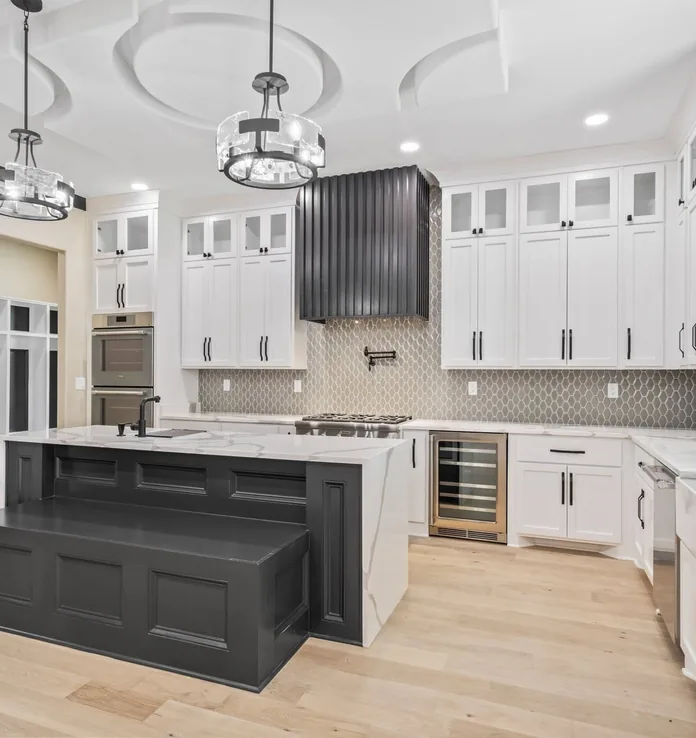 A finished kitchen with an island and pendant lighting