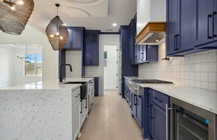 A renovated kitchen with an island and pendant lighting